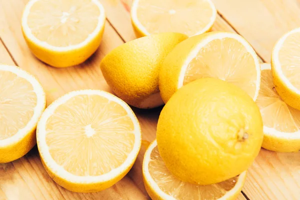 Vista de cerca de limones jugosos, frescos y amarillos sobre fondo de superficie de madera - foto de stock