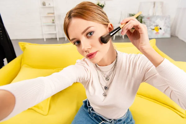 Blogueiro de beleza fazendo maquiagem enquanto toma selfie em casa — Fotografia de Stock