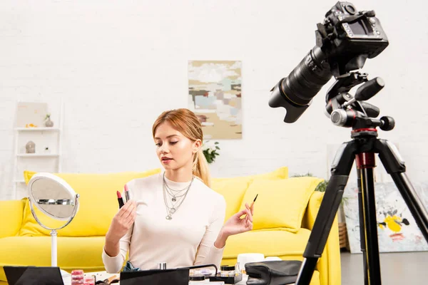 Beauty blogger holding lipsticks in front of video camera — Stock Photo