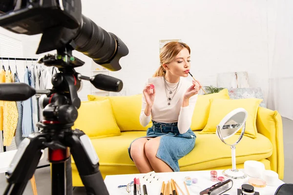 Belleza blogger aplicando brillo labial delante de la cámara de vídeo - foto de stock