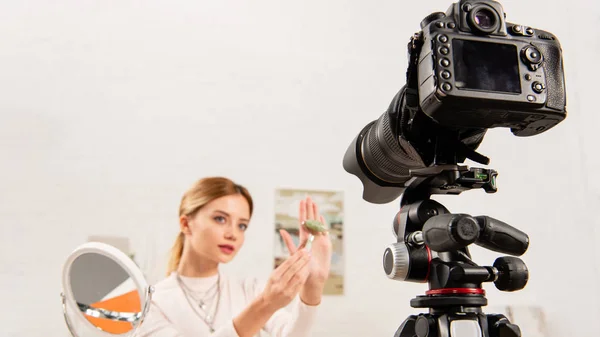 Beauty blogger showing jade roller in front of video camera — Stock Photo