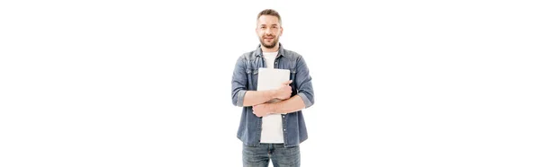Панорамний знімок усміхненого чоловіка в джинсовій сорочці, що тримає ноутбук ізольовано на білому — стокове фото