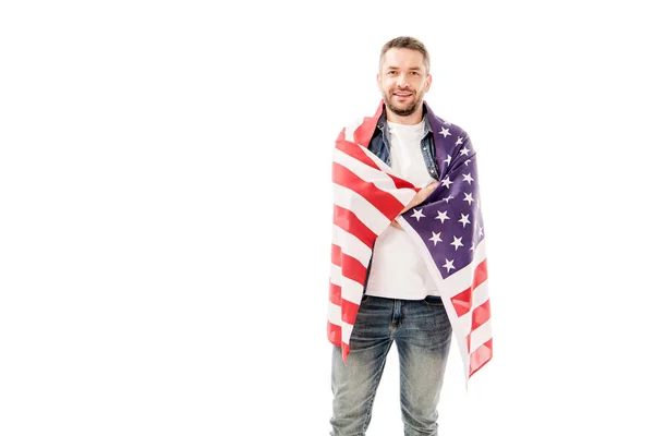 Vista frontal del hombre barbudo sonriente sosteniendo bandera americana aislada en blanco - foto de stock