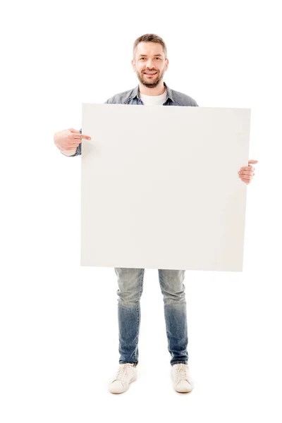 Vue pleine longueur de l'homme barbu souriant tenant une pancarte vierge isolée sur blanc — Photo de stock