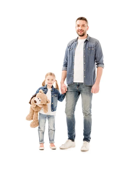 Vista completa de papá y su hija sonrientes en jeans tomados de la mano aislados en blanco - foto de stock