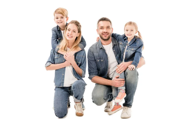 Família feliz em jeans abraçando e sorrindo isolado no branco — Fotografia de Stock