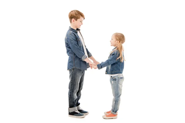 Vue latérale des enfants tenant la main et se regardant isolés sur blanc — Photo de stock
