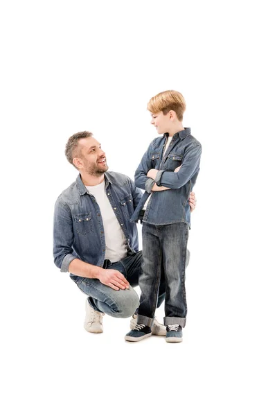 Smiling father and son looking at each other isolated on white — Stock Photo