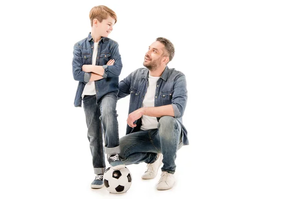 Hijo y papá con pelota de fútbol mirándose aislados en blanco — Stock Photo