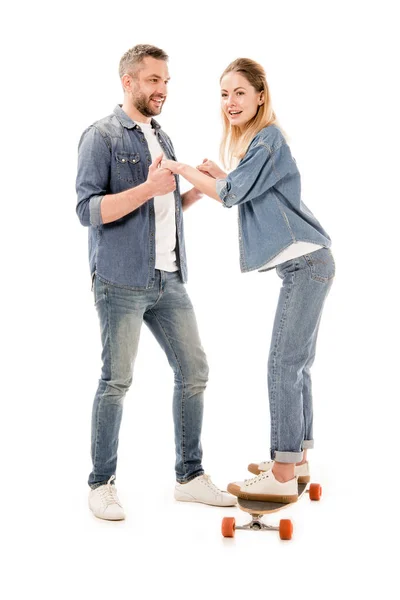 Visão de comprimento total do casal com skate segurando as mãos isoladas no branco — Fotografia de Stock