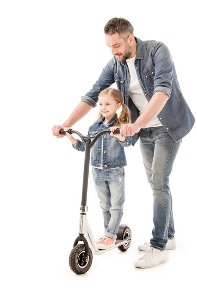 Piena vista di sorridente papà e figlia con scooter isolato su bianco — Foto stock