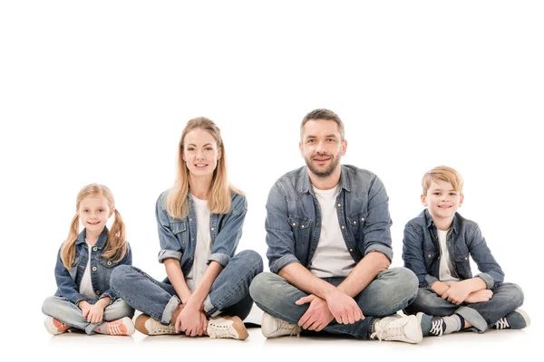 Glückliche Familie in Jeans sitzt isoliert auf weiß — Stockfoto