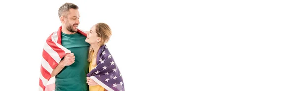 Panoramic shot of smiling couple with american flag embracing and looking at each other isolated on white — Stock Photo