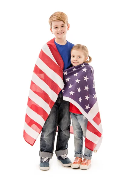 Ganzkörperansicht lächelnder Kinder mit amerikanischer Flagge, die isoliert auf weiß in die Kamera schauen — Stockfoto