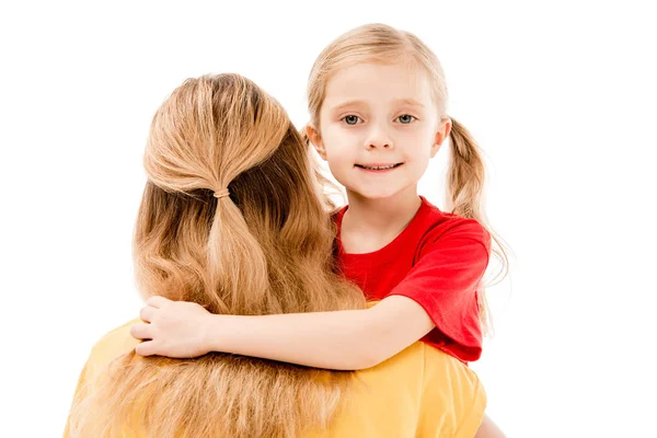 Hija abrazando madre y sonriendo aislado en blanco - foto de stock