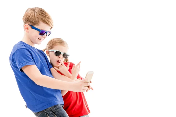 Duas crianças em óculos de sol tomando selfie isolado em branco — Fotografia de Stock