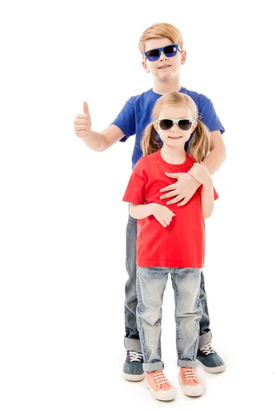 Full length view of sister and brother in sunglasses embracing isolated on white — Stock Photo
