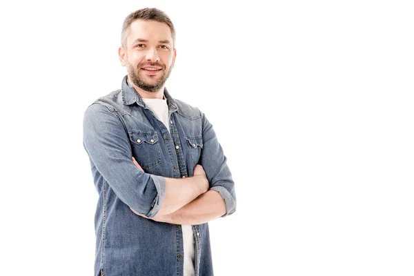 Uomo barbuto sorridente in camicia di jeans in piedi con braccia incrociate isolato su bianco — Foto stock