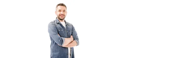 Colpo panoramico di uomo barbuto sorridente in camicia di jeans in piedi con le braccia incrociate isolato su bianco — Foto stock