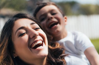 selective focus of happy mother laughing with cute son clipart