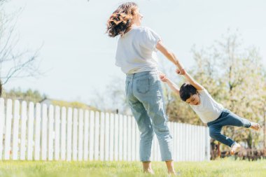 Mutlu anne, tatlı oğluyla el ele tutuşup dışarıda vakit geçiriyor.