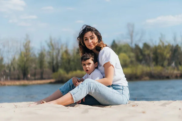 Mor Och Son Sitter Sand Nära Floden — Stockfoto