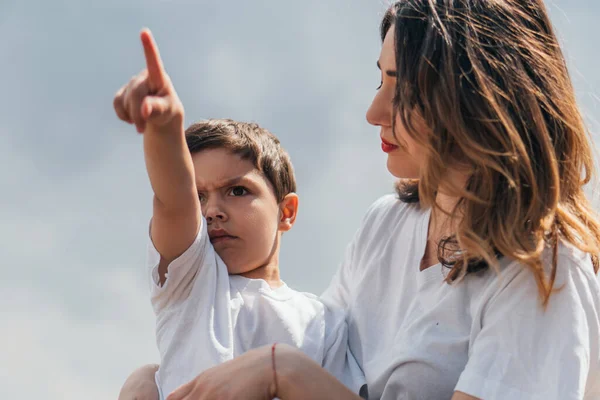 Menino Sério Apontando Com Dedo Perto Mãe Atraente — Fotografia de Stock