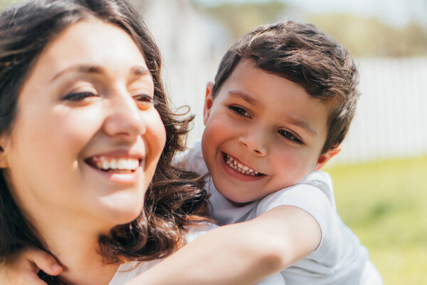 избирательный фокус счастливого сына обнимающего весёлую мать
