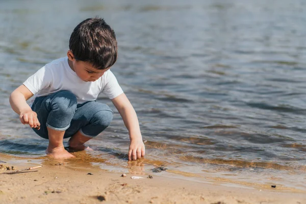 Anak Manis Duduk Dalam Air Dan Menyentuh Pasir Basah Stok Foto Bebas Royalti