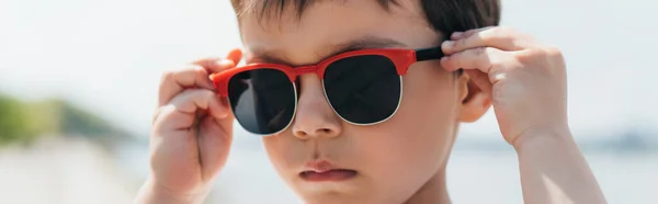 Panoramic shot of cute and serious boy wearing stylish sunglasses — Stock Photo