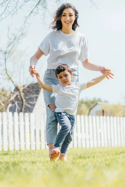 Happy mother holding hands with cute son outside — Stock Photo