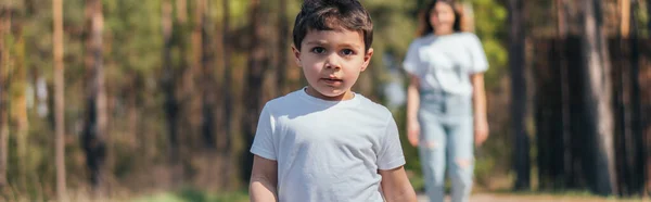 Horizontales Konzept des niedlichen Jungen, der in die Kamera in der Nähe der Mutter schaut — Stockfoto