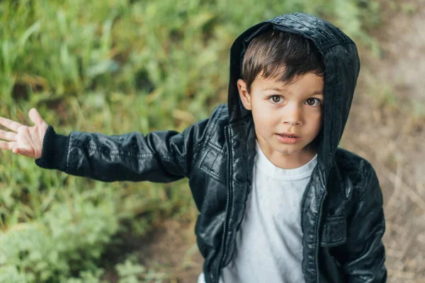 Blick aus der Vogelperspektive auf den niedlichen Jungen in schwarzer Jacke, der in die Kamera schaut — Stockfoto