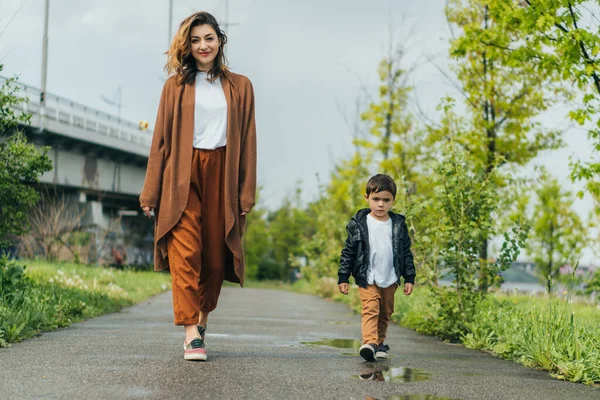 Mère gaie et fils mignon marchant dehors — Photo de stock