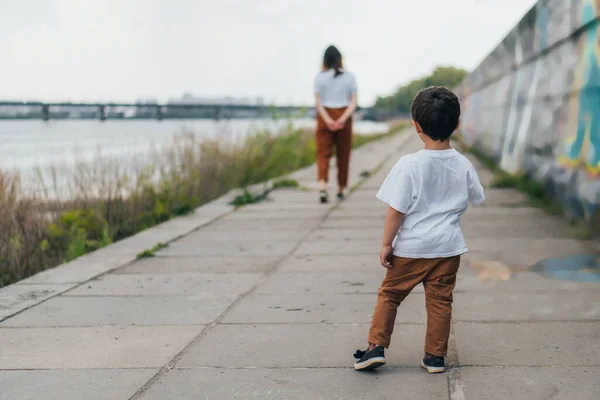 Back view of kid standing and looking at mother — Stock Photo