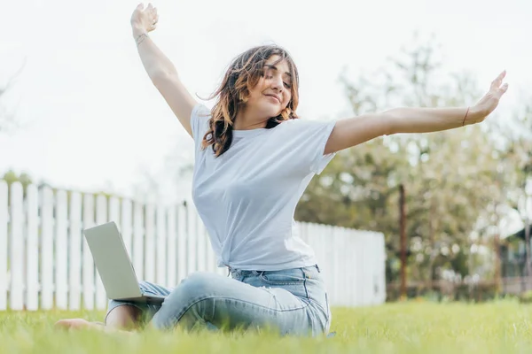 Enfoque selectivo de freelancer feliz con las manos extendidas cerca de la computadora portátil - foto de stock