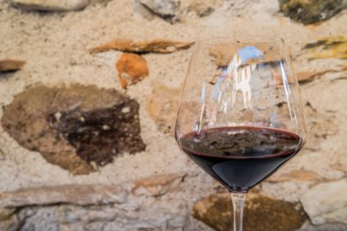 İtalyan kırmızı şarabının yakın plan fotoğrafı, arka planda kaya duvarı.