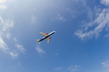 Mavi güneşli gökyüzünde uçan yolcu uçağı