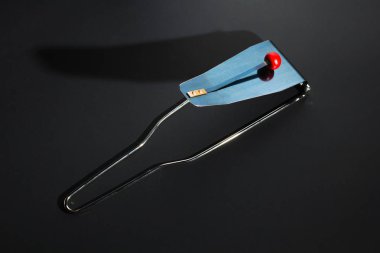 Flexatone, fleximetal (idiophone vurdu) - mavi çelik plaka ve kırmızı ahşap top oluşan modern perküsyon müzik aleti