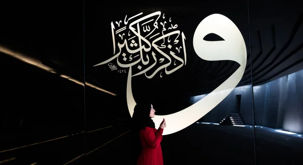 中年穆斯林妇女穿着红衣服在 Sancaklar 清真寺里祈祷 背景是阿拉伯文字母和韵文 Buyukcekmece Istanbul Turkey30 2017年7月 — 图库照片
