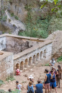 Mağara Silifke Cennet Çöküğü doğru taş merdivenle kimliği belirsiz insanlar district.St. Paulus arka planda şapeldir. Mersin Turkey.29 Ağustos 2017.