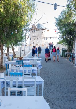 Kimliği belirsiz kişi Yürüyüş Caddesi ile kafe ve restoran ile masa ve sandalyeler etrafında Alaçatı şehir, seyahat ve tatil Izmir,Turkey.26 Ağustos 2017 için popüler bir hedef.