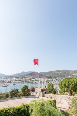 Türk bayrağı sallayarak ile St. Peter Kalesi veya Bodrum Kalesi ve deniz hava görünümü ile Bodrum'da yat limanına Türkiye'de.