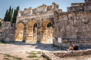 Hierapolis antik kenti Pamukkale, Turkey.25 Ağustos 2017 yılında Bizans geçidin yakınlarında kadın oturur