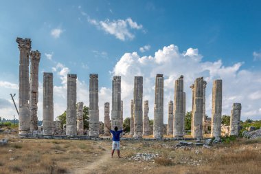 Genç adam t-shirt, silah ile açık açık zevk özgürlük Uzuncaburç, Silifke, Mersin, Türkiye'de bulunan antik antik kenti Zeus tapınağında yaymak.