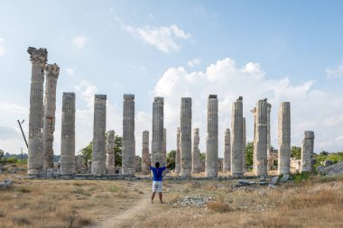 Genç adam t-shirt, silah ile açık açık zevk özgürlük Uzuncaburç, Silifke, Mersin, Türkiye'de bulunan antik antik kenti Zeus tapınağında yaymak.