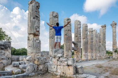 Genç adam t-shirt, silah ile açık açık zevk özgürlük Uzuncaburç, Silifke, Mersin, Türkiye'de bulunan antik antik kenti Zeus tapınağında yaymak.