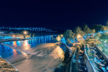 Kimliği belirsiz kişi on gözlü köprü, orta Diyarbakır, Türkiye'nin popüler bir dönüm noktası yakınında oturmak.