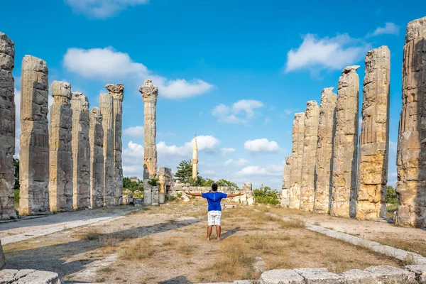 Genç adam t-shirt, silah ile açık açık zevk özgürlük Uzuncaburç, Silifke, Mersin, Türkiye'de bulunan antik antik kenti Zeus tapınağında yaymak.