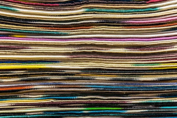 Traditional colorful silk ,cashmere head scarves or shawls and fabrics composed of a stack background at the bazaar stall in Istanbul, Turkey